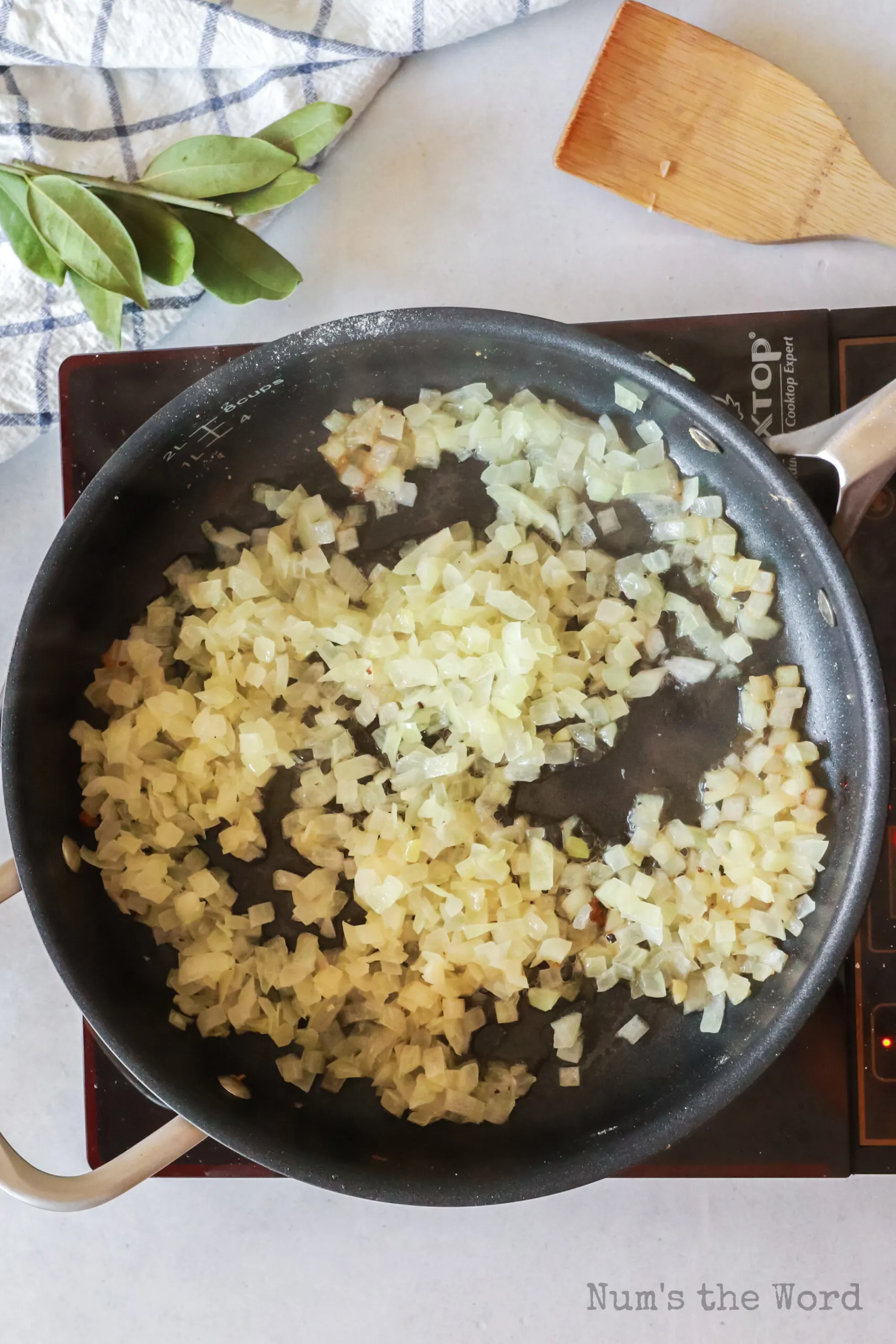 Onion being sautéed in skillet before adding it to the crock pot.