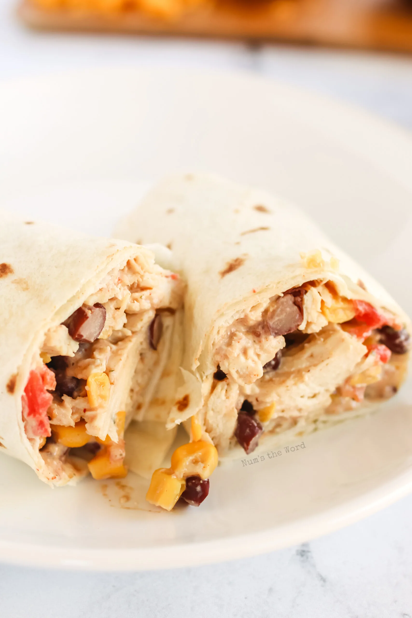 close up of cut chicken wrap on plate.