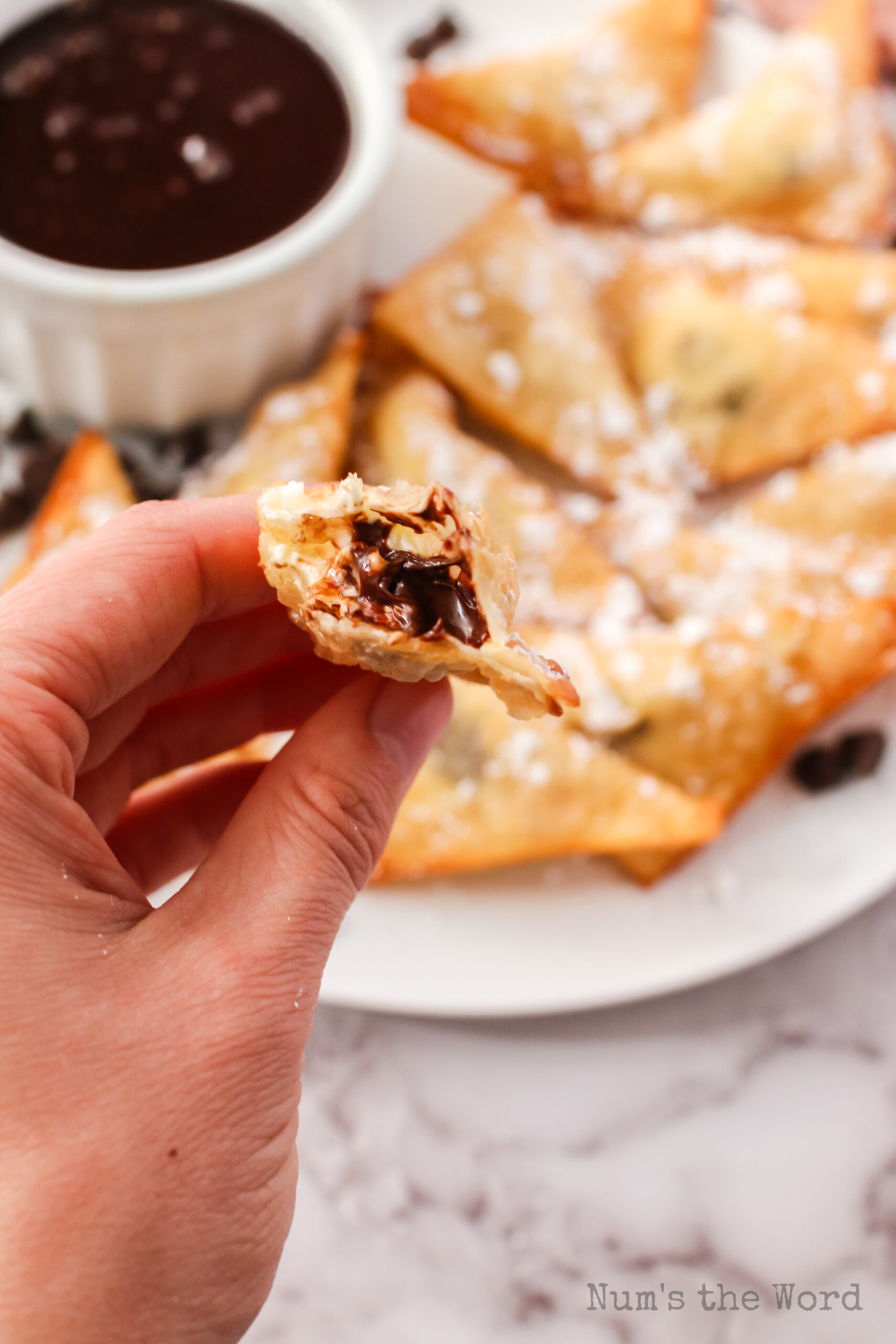 bite removed from a dessert wonton to show creamy insides