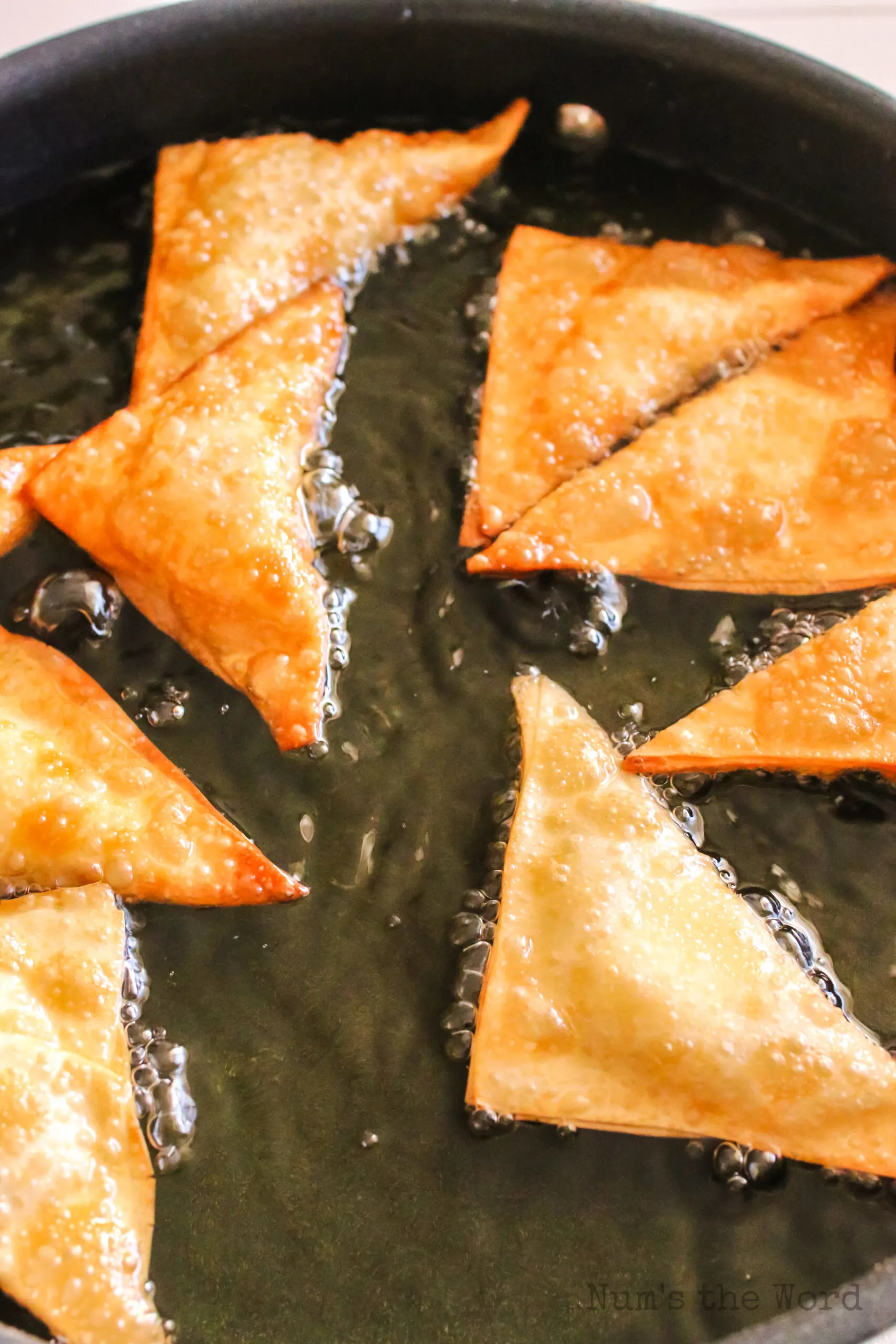 cooked wontons in oil about to be removed