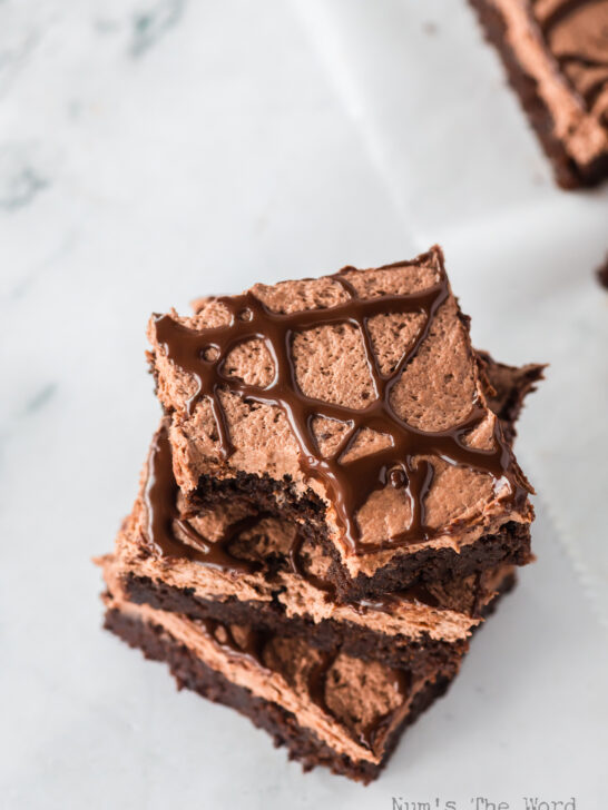 3 brownies stacked up on top of each other. Top brownie has a bite removed. Photo taken from the top looking down