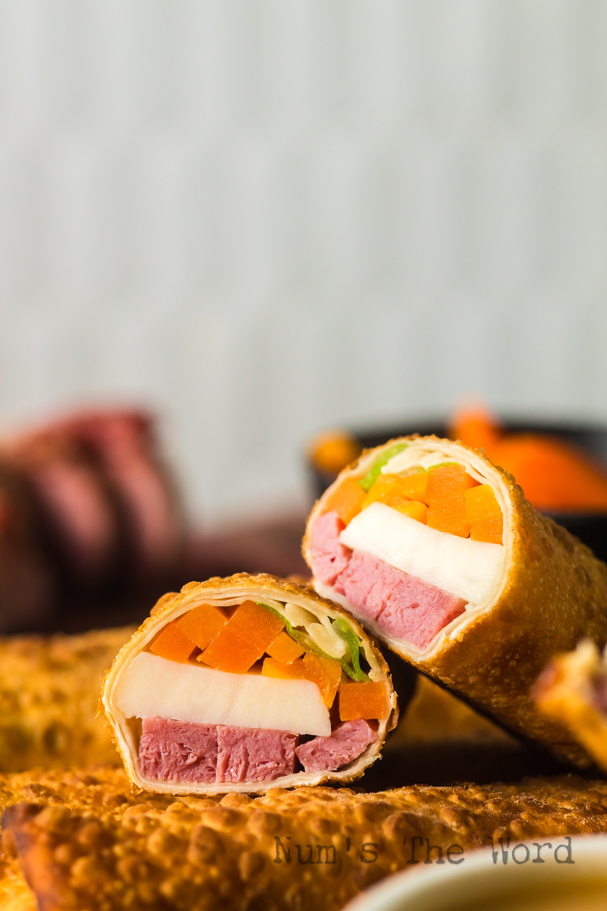 zoomed in image of egg roll on platter ready to serve with one cut in half.
