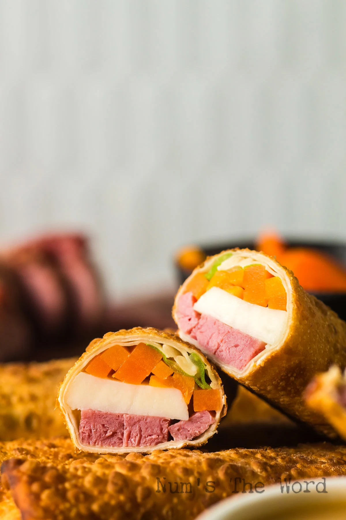 zoomed in image of egg roll on platter ready to serve with one cut in half.