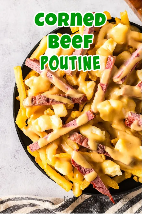 Main image for Corned Beef Poutine. Poutine is piled high on a plate ready to eat.