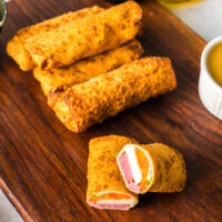 zoomed out image of cooked eggrolls with filling showing in one.