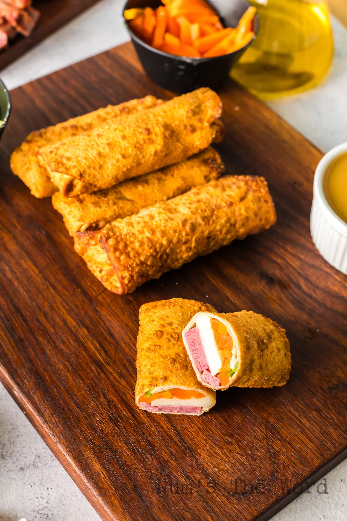 zoomed out image of cooked eggrolls with filling showing in one.