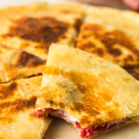 quesadilla on plate with a bite out of one slice.