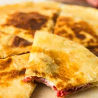 quesadilla on plate with a bite out of one slice.