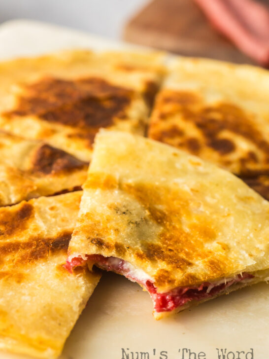quesadilla on plate with a bite out of one slice.