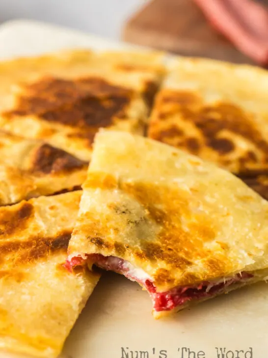 quesadilla on plate with a bite out of one slice.