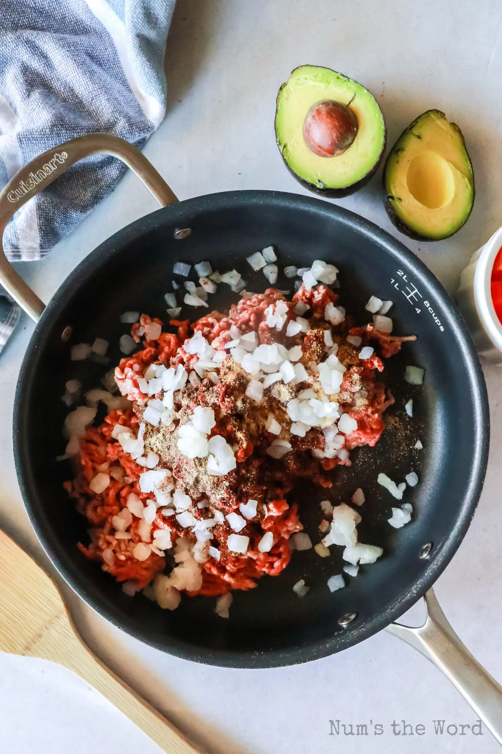 ground beef, chili powder, salt, cumin, black pepper, garlic powder, onion powder, cayenne pepper and onion in a skillet