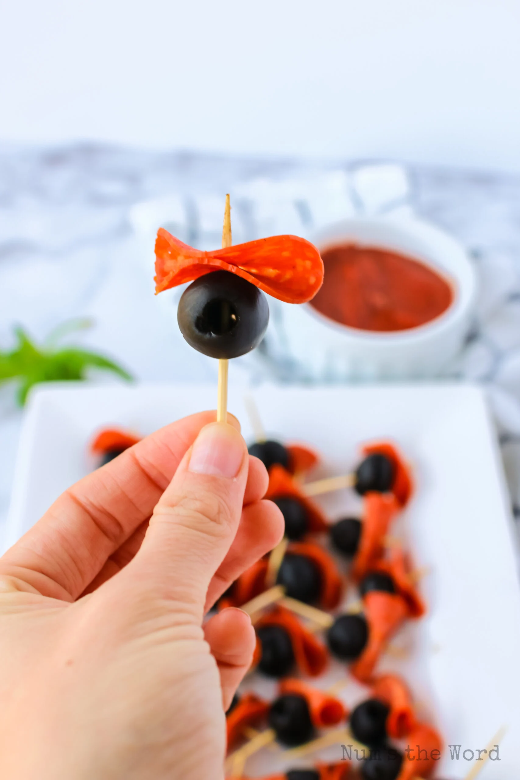 pepperoni folded and placed under the olive on toothpick