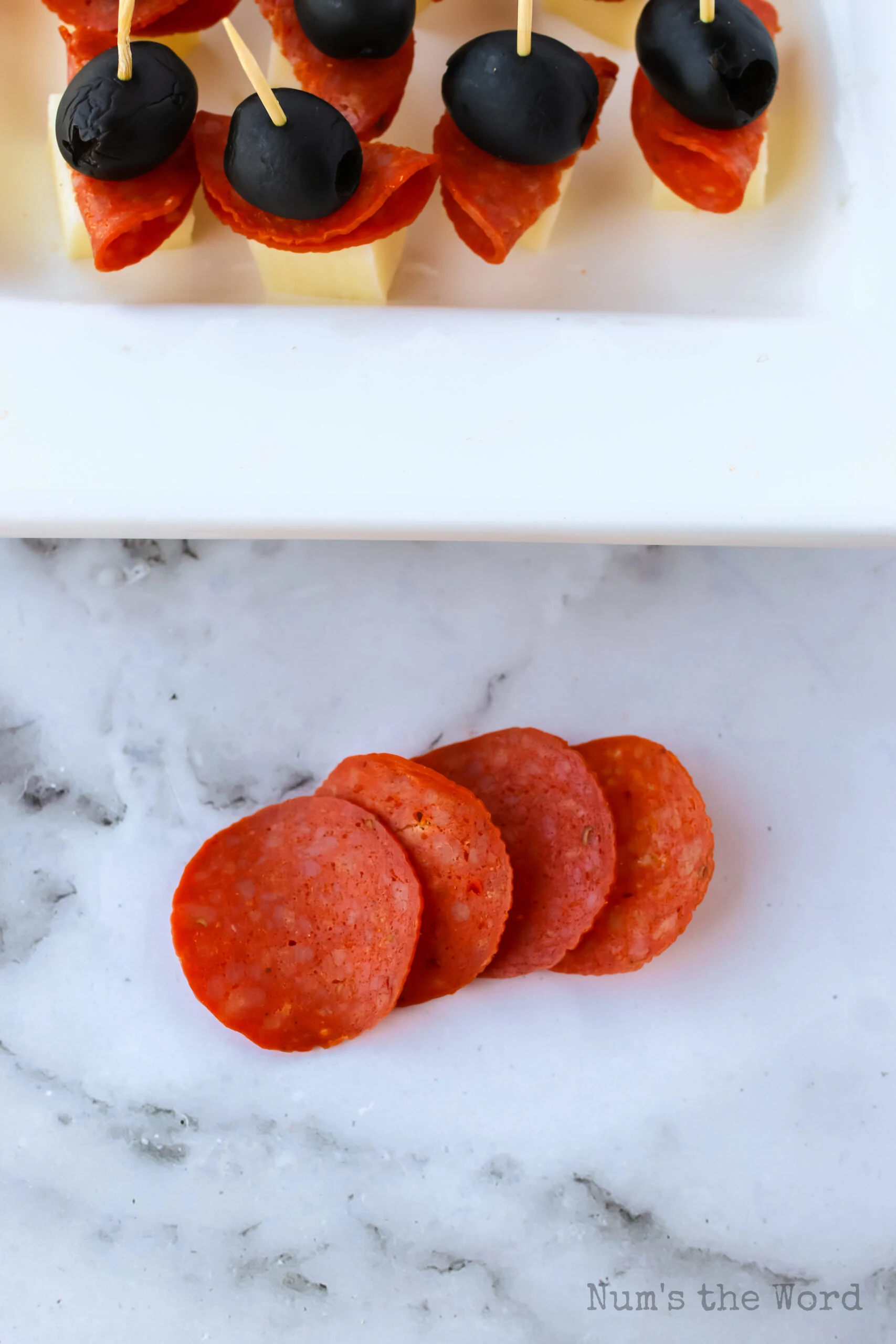 4 pepperoni slices layered in preparation for a pepperoni rose