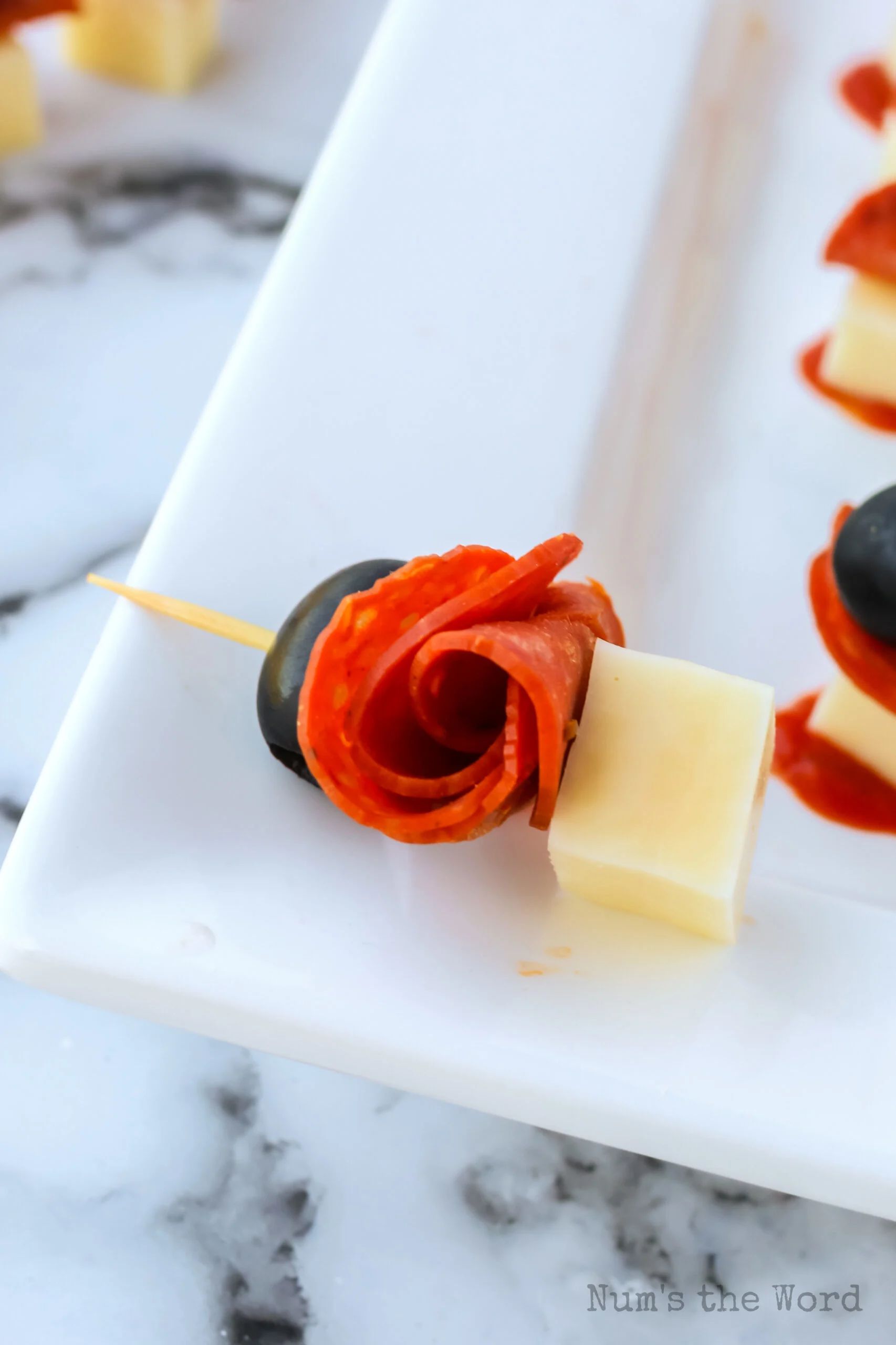 a mozzarella pepperoni bite laid out on a platter