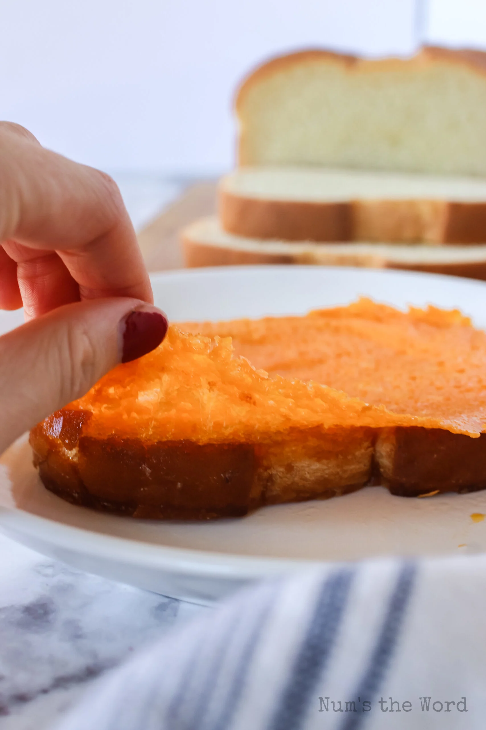 hand pulling up cheese off bread to show how gooey it is