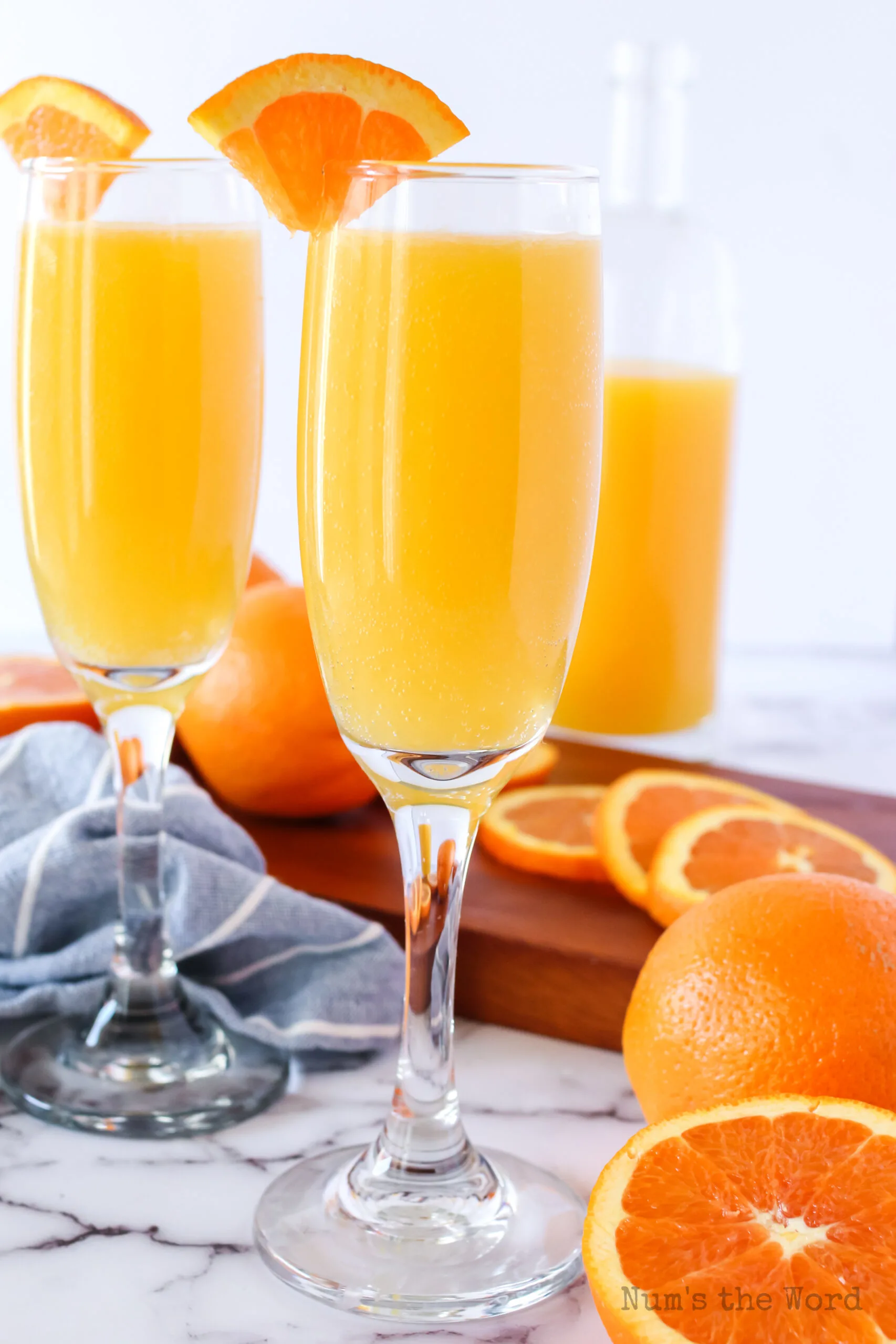 zoomed out image of two glasses of non alcoholic mimosas.