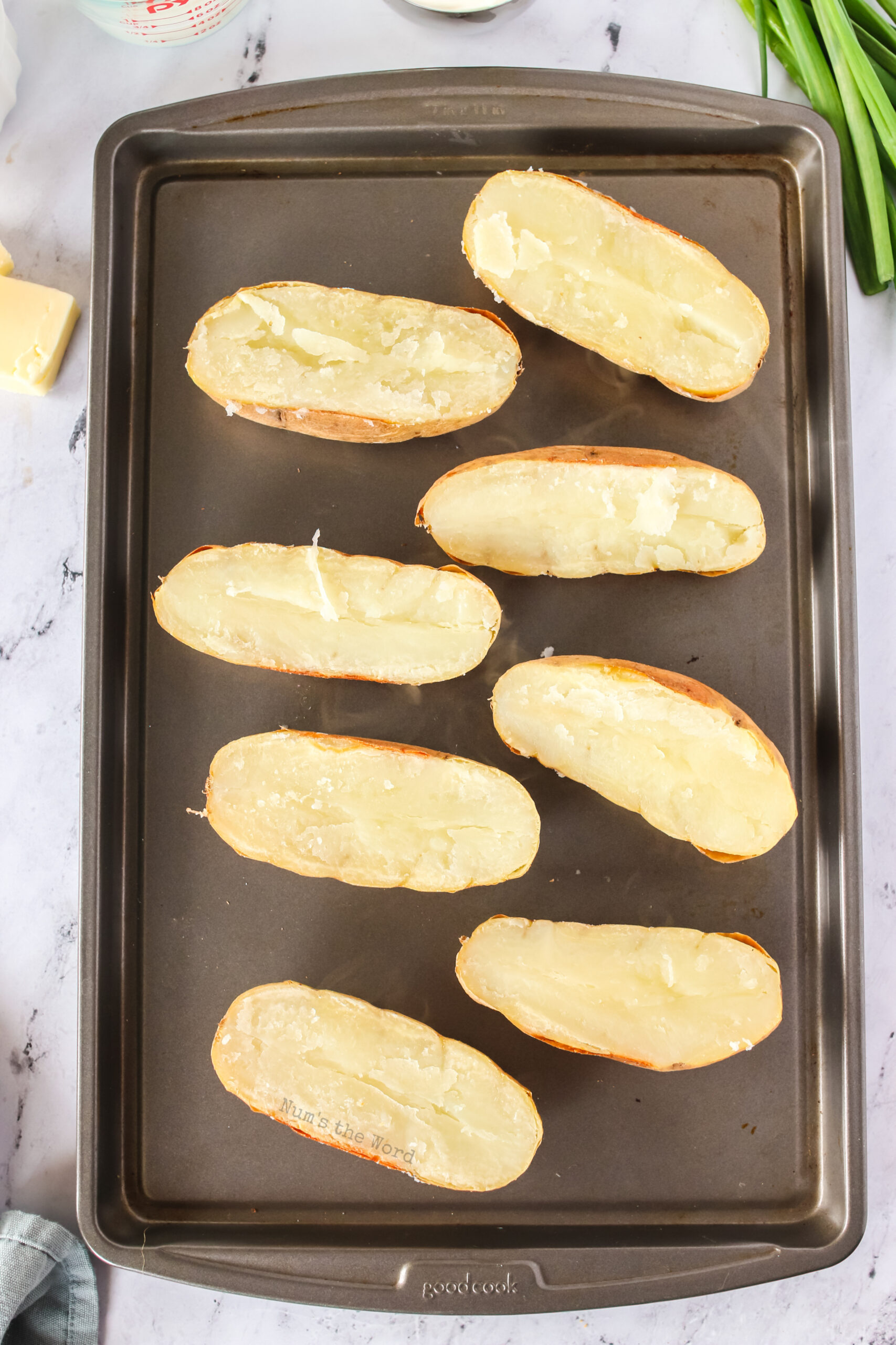 4 baked potatoes are split in half on a cookie sheet