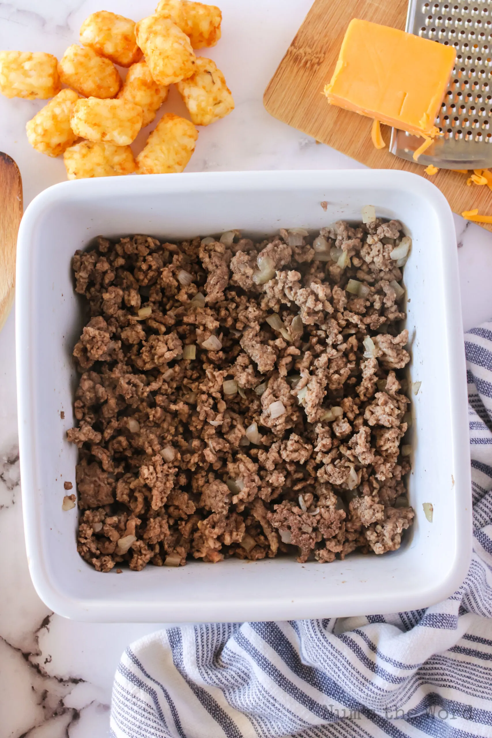 ground beef and onions are cooked and in 9 inch casserole dish