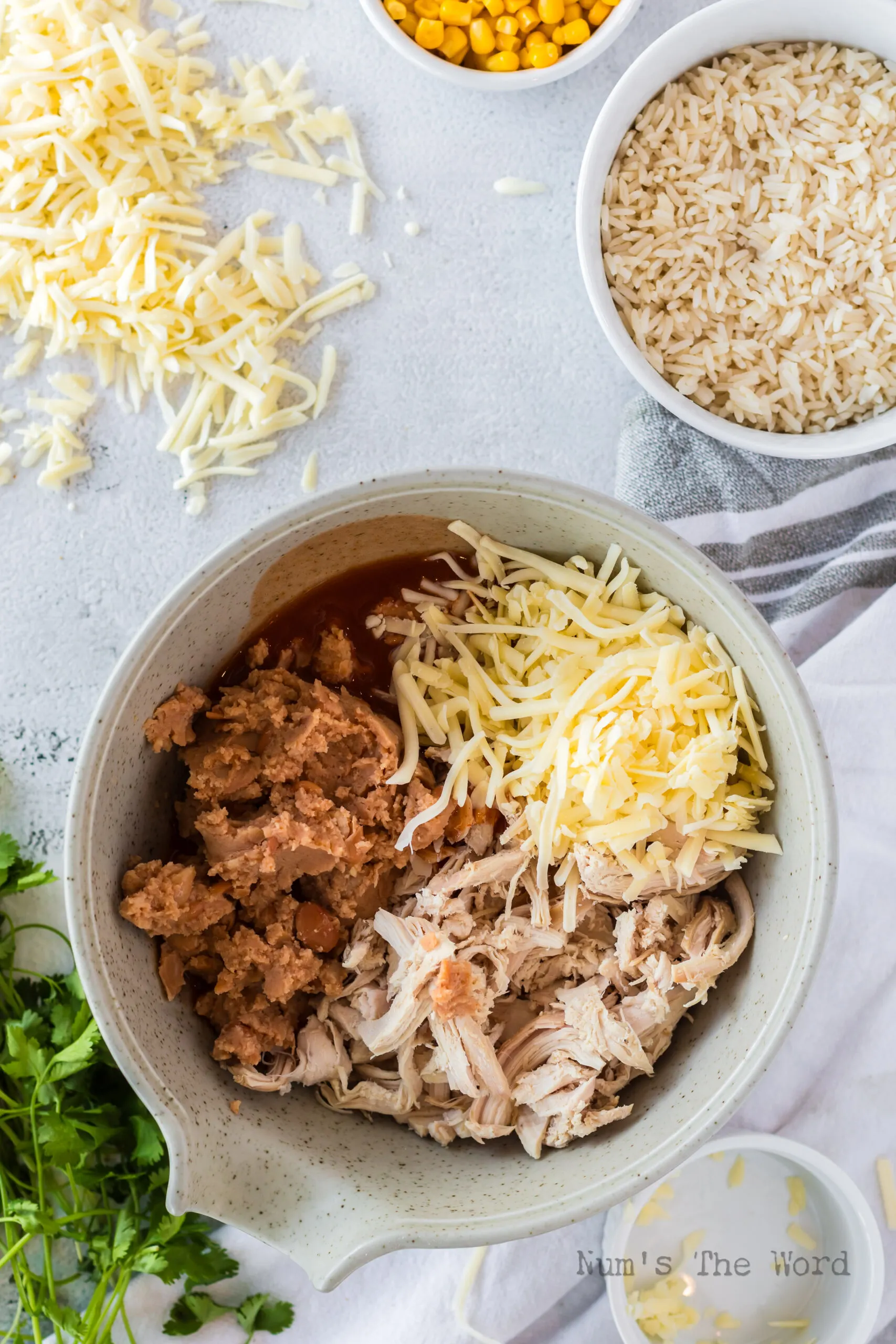 Shredded chicken, refried beans, and cheese in a bowl