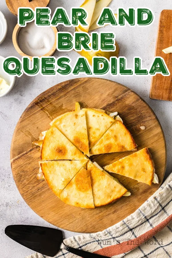 Main image for Pear and Brie Quesadilla recipe. Quesadilla on a round cutting board, cut.