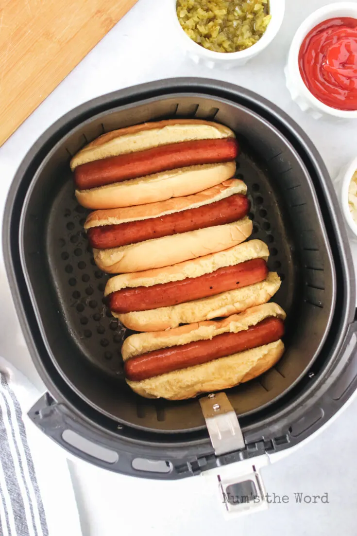 cooked hot dogs with buns in the air fryer, ready to serve.