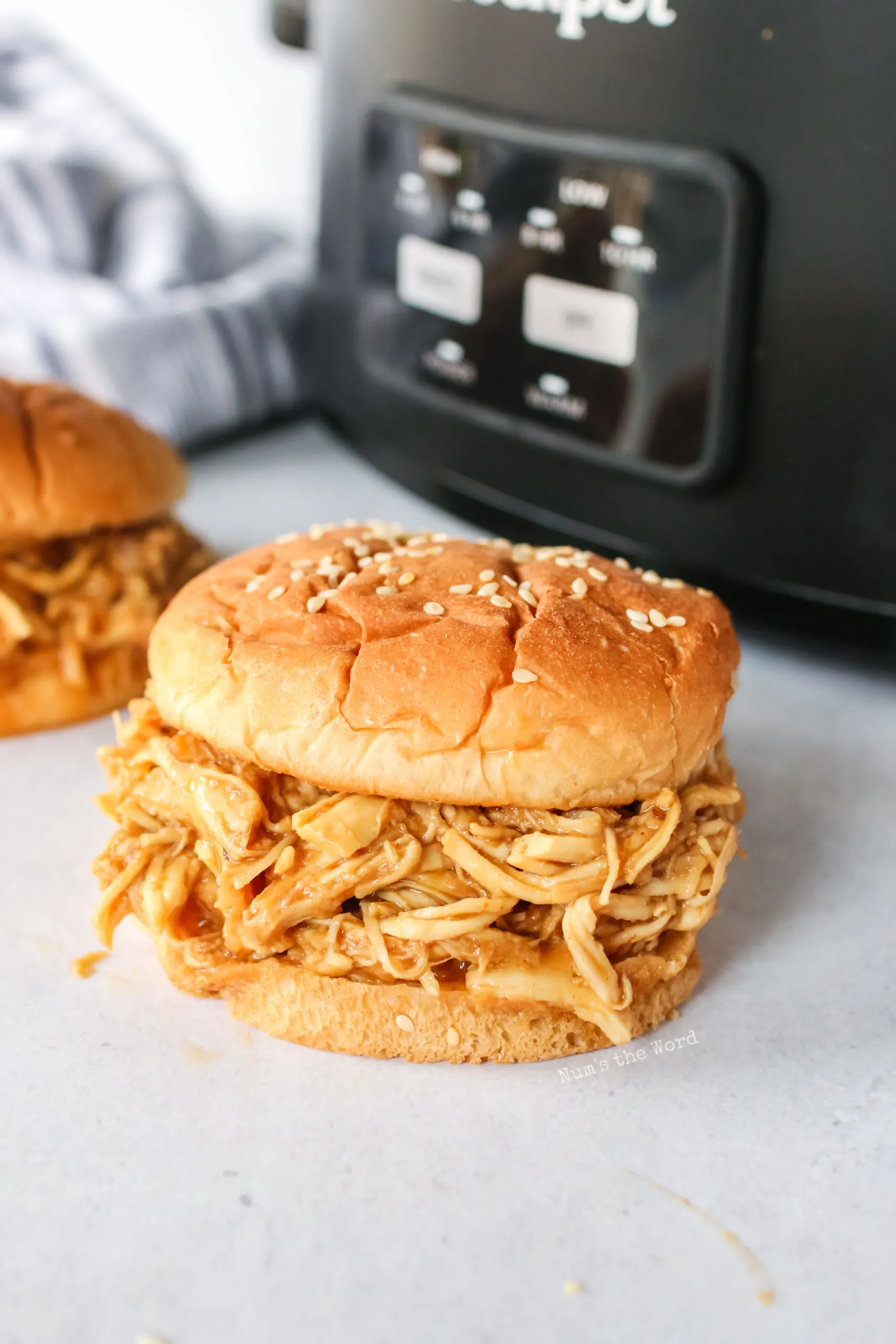 pulled pork sandwiches in front of crock pot, ready to eat.