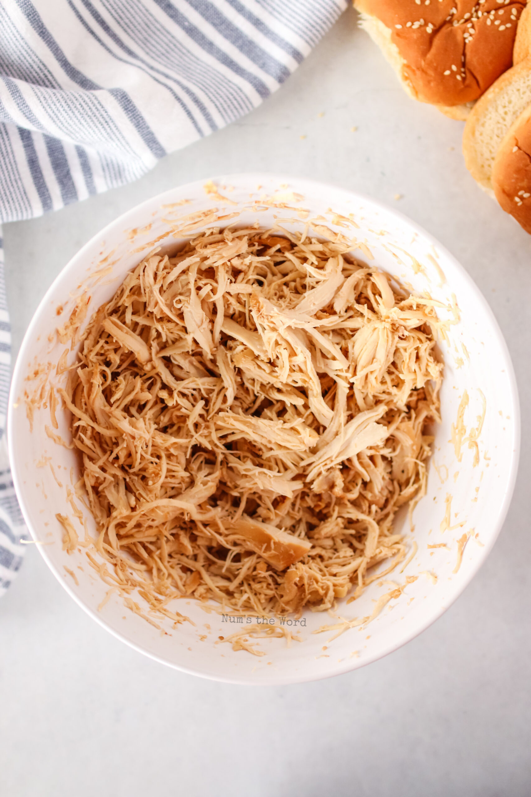 chicken pulled in a bowl, ready to be added back into crock pot.