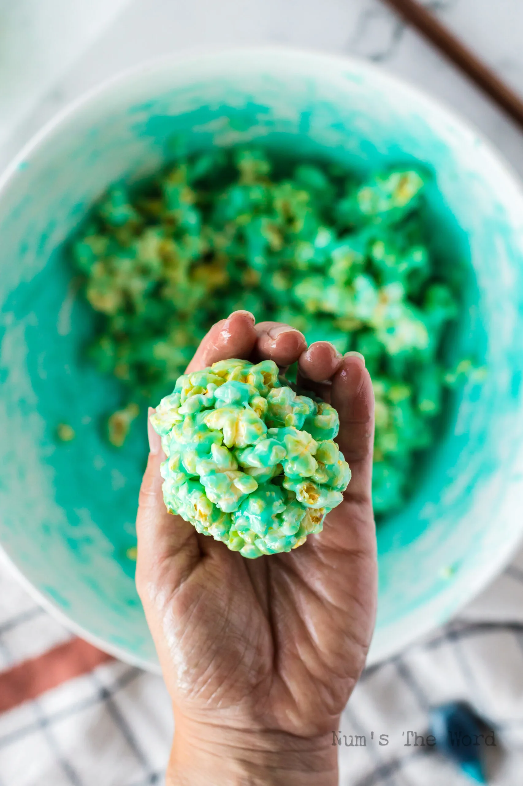 buttered hands rolling up a popcorn ball