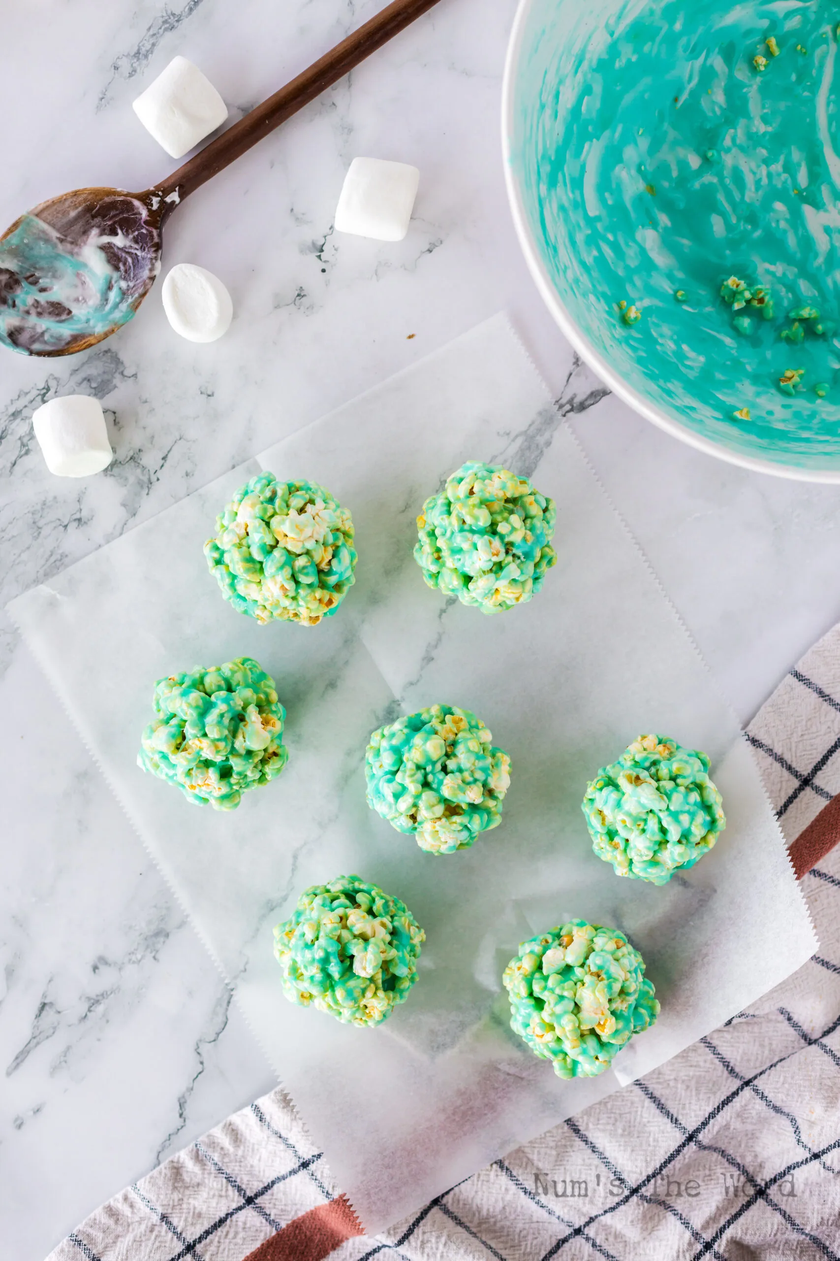 7 popcorn balls laid out on parchment paper