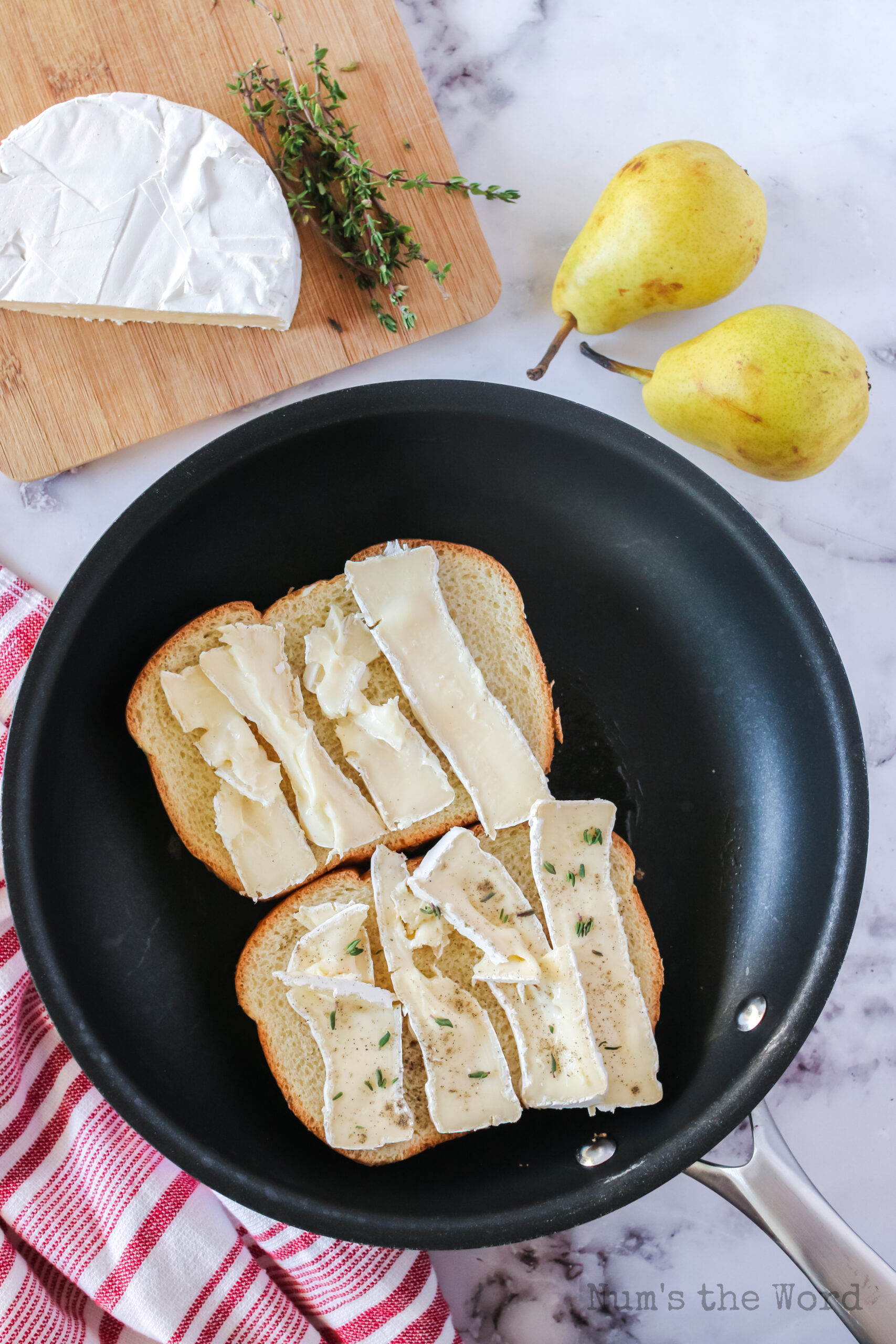 Brie on two slices of bread with thyme and brie on top of each slice.