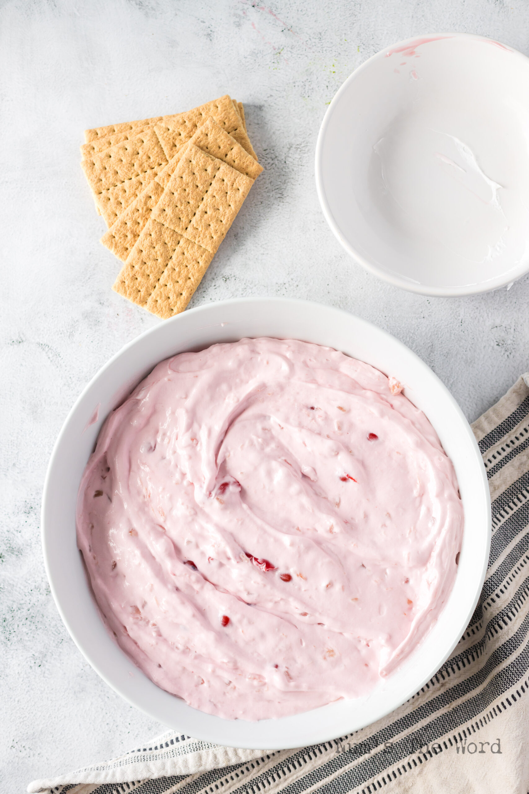 cherry pie dip in bowl with graham crackers next to the bowl.