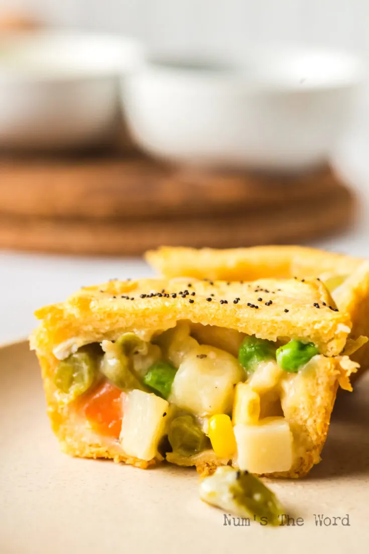Baked Chicken Pot Pie Stuffed Biscuit removed from muffin tin and cut in half to show creamy filling.