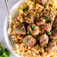 top view of meatballs over egg noodles with gravy