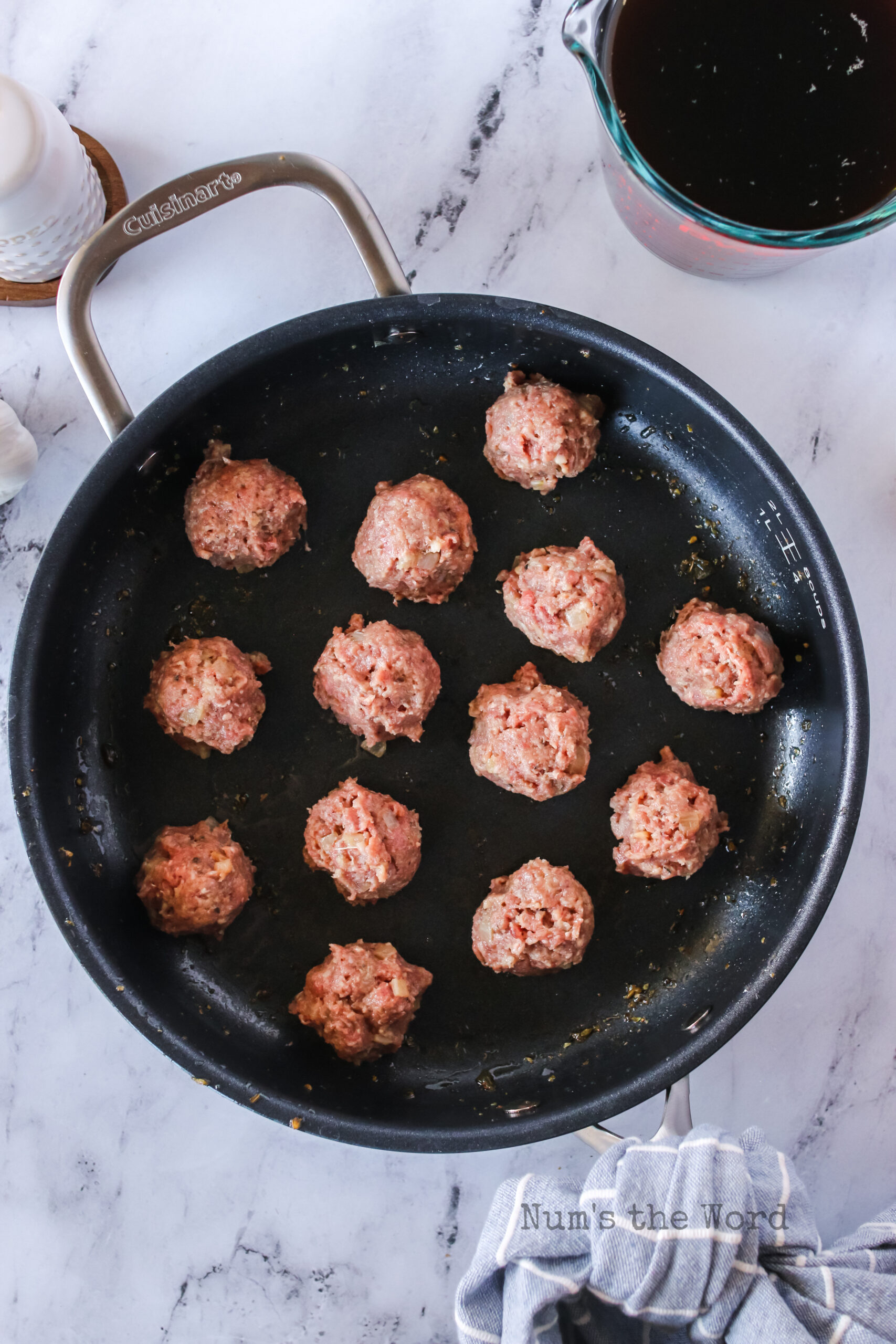 Meatballs placed in a hot skillet.