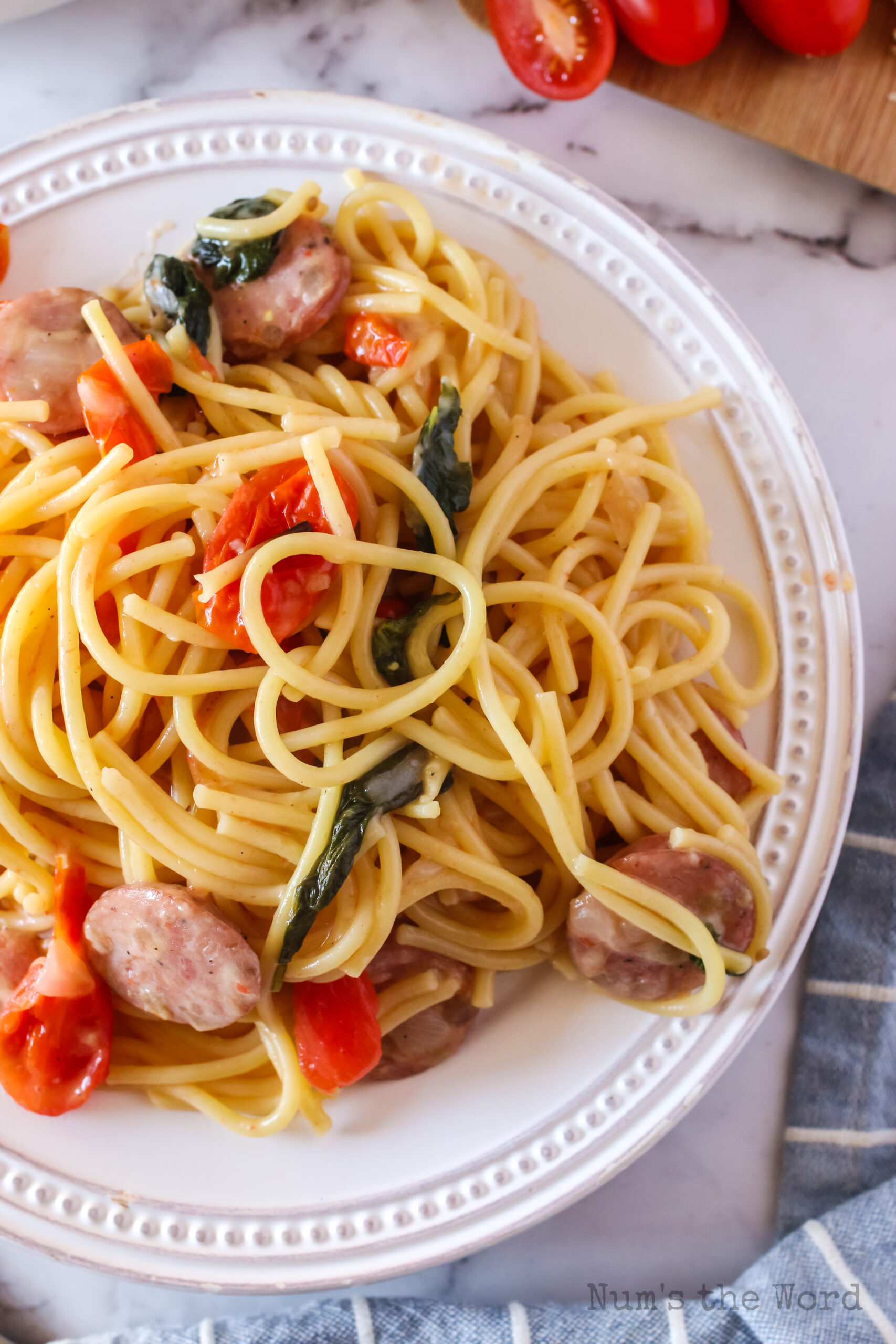 close up view of tomato basil sausage spaghetti on plate