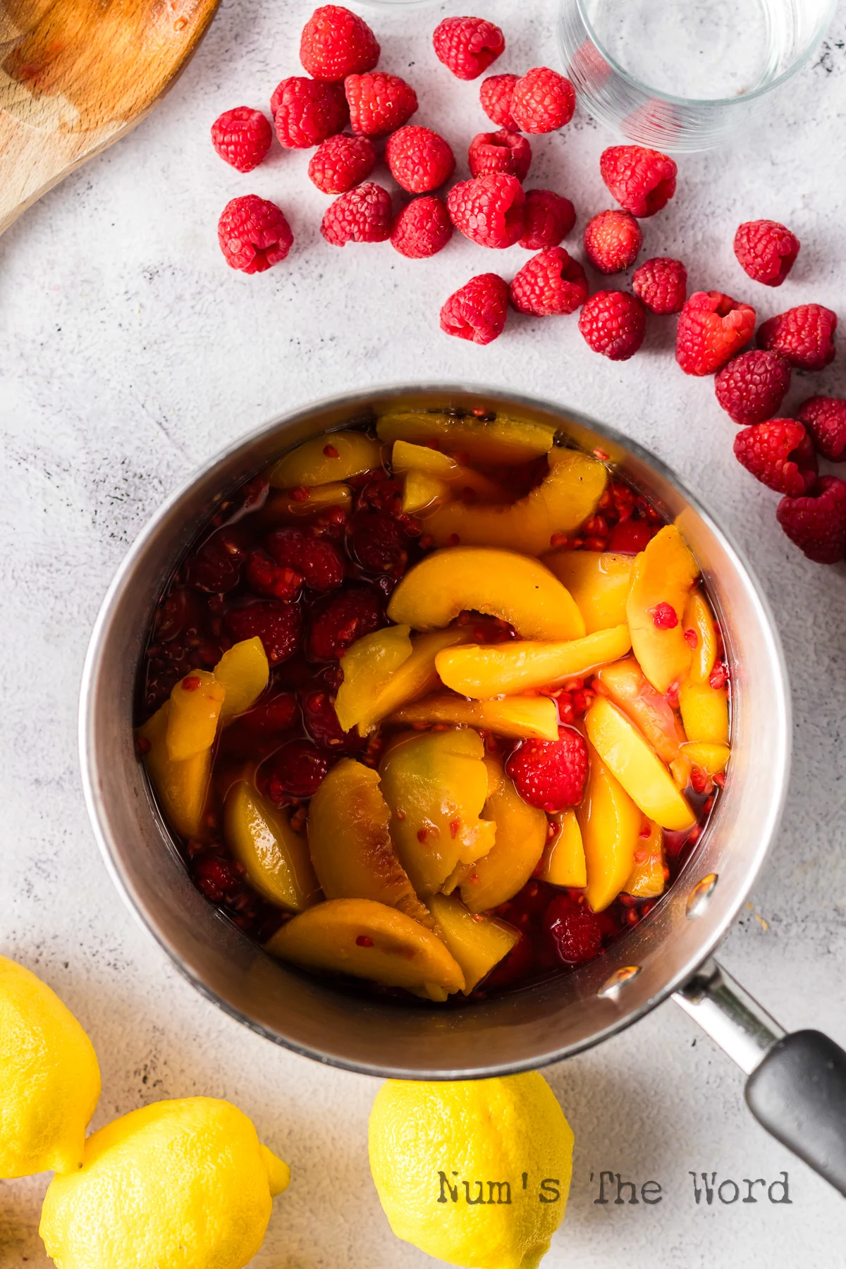 water, sugar, peaches and raspberries added to a pot.