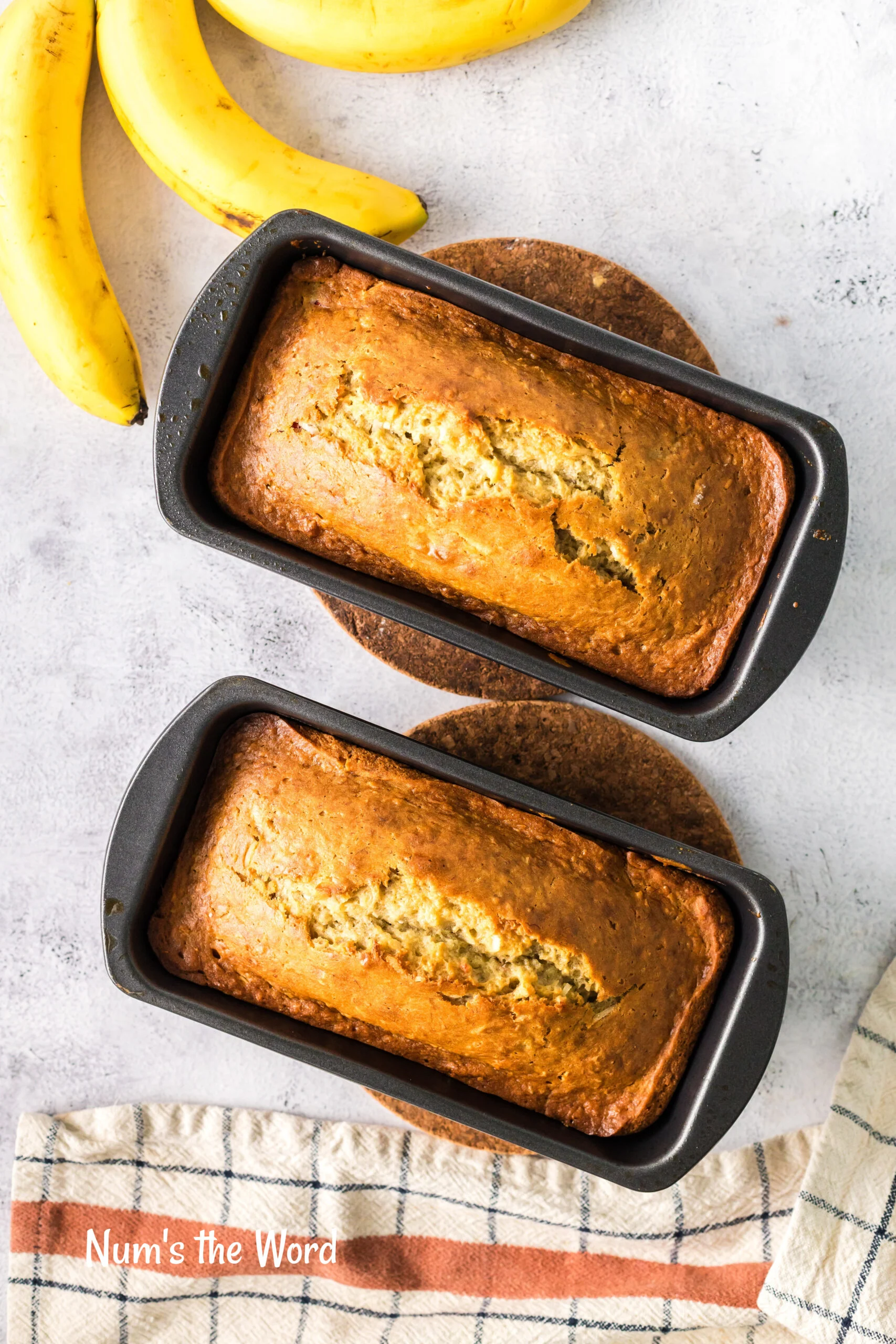 Two loaves of bread in bread pans fresh from the oven.