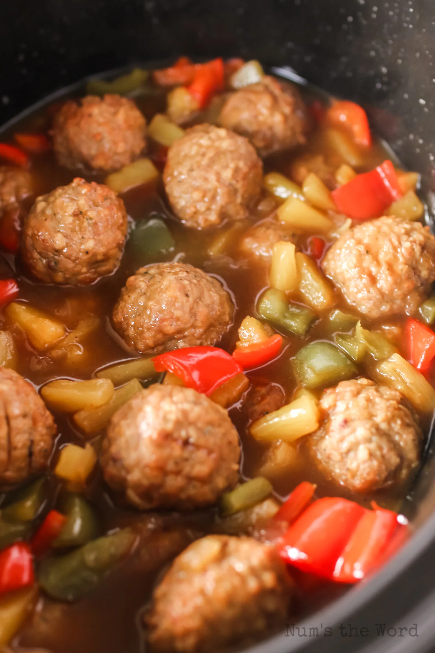 zoomed in image of sweet and sour meatballs in slow cooker