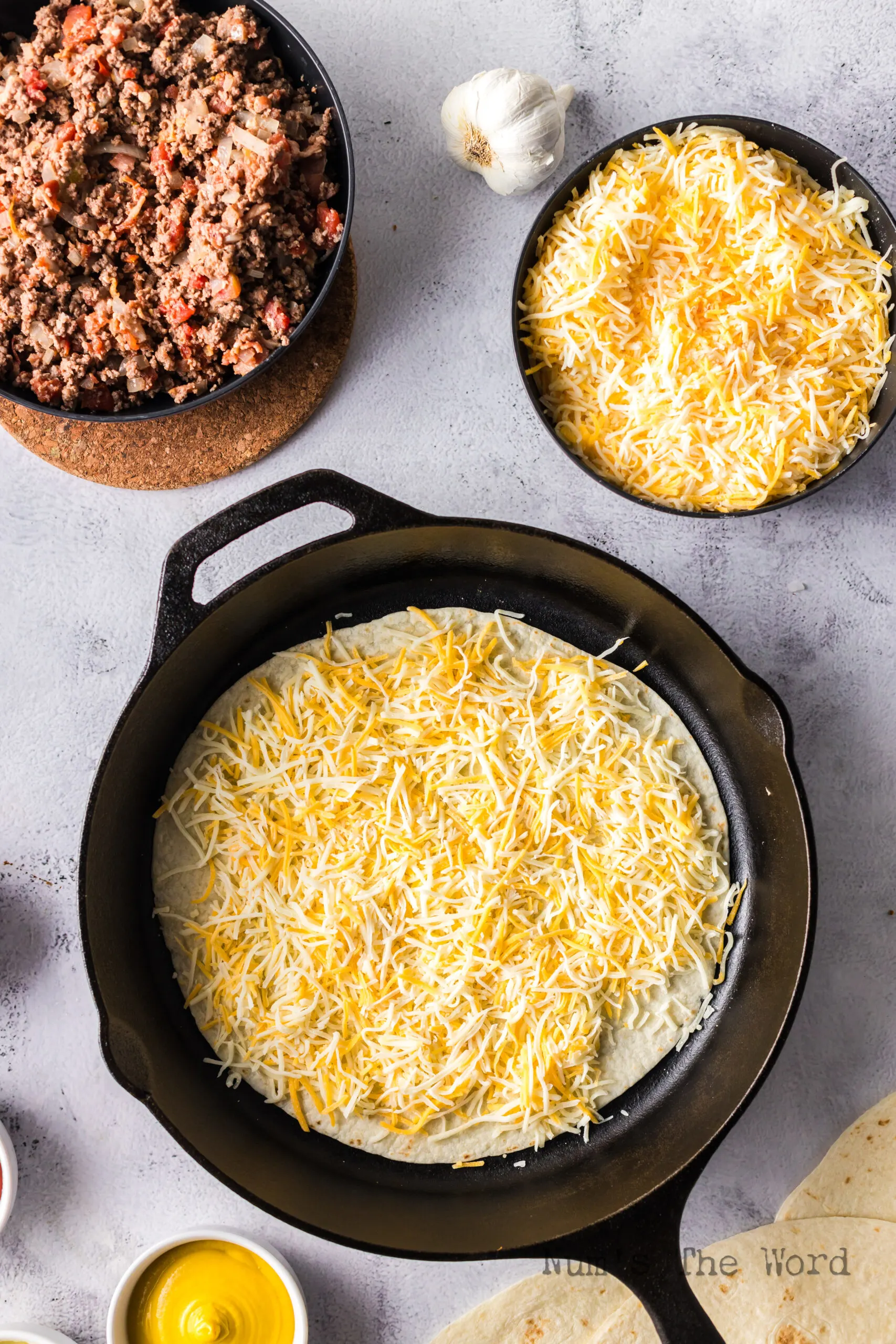 layer of cheese on top of tortilla in a skillet