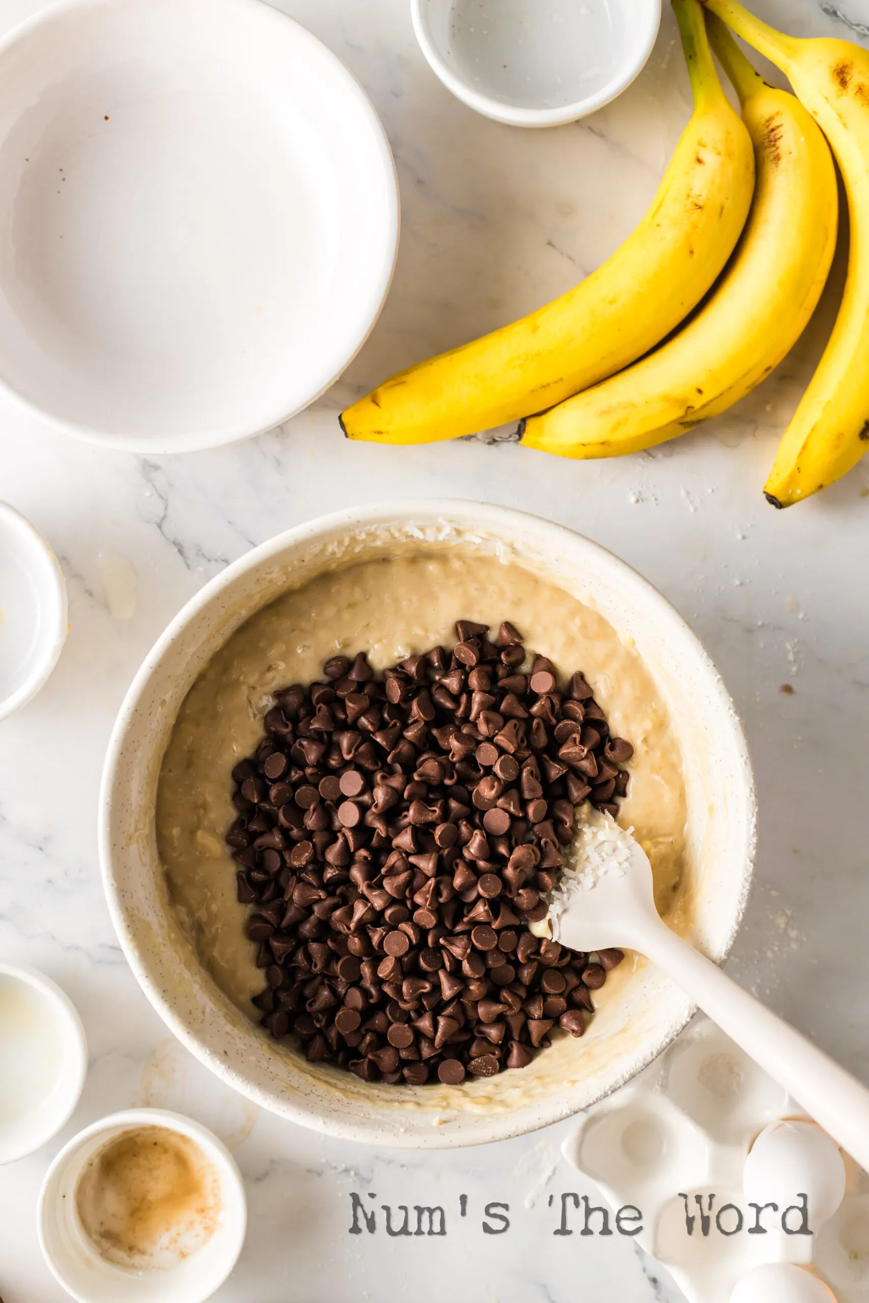 Banana coconut batter with chocolate chips being added