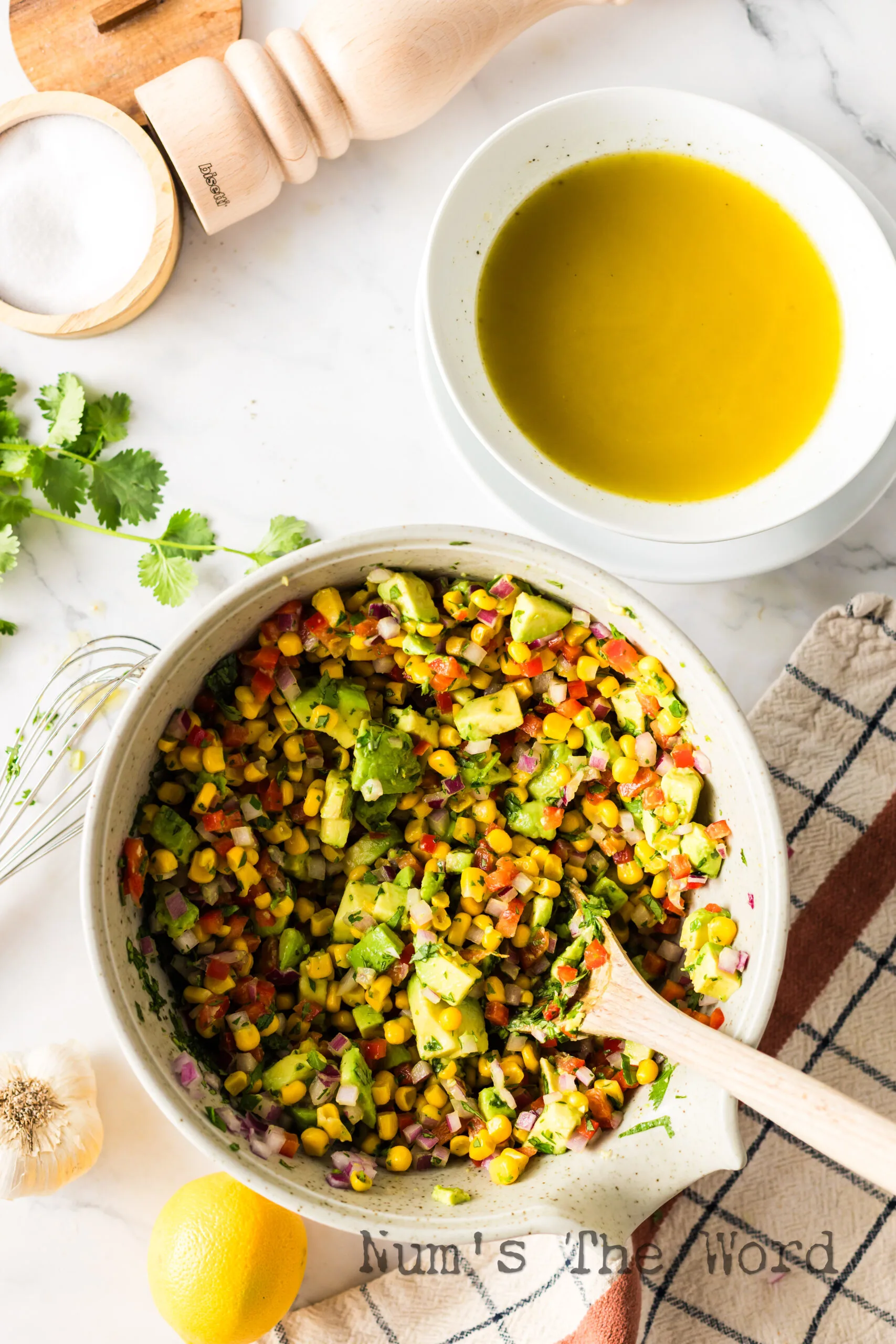 Spoon stirring salsa with dressing.