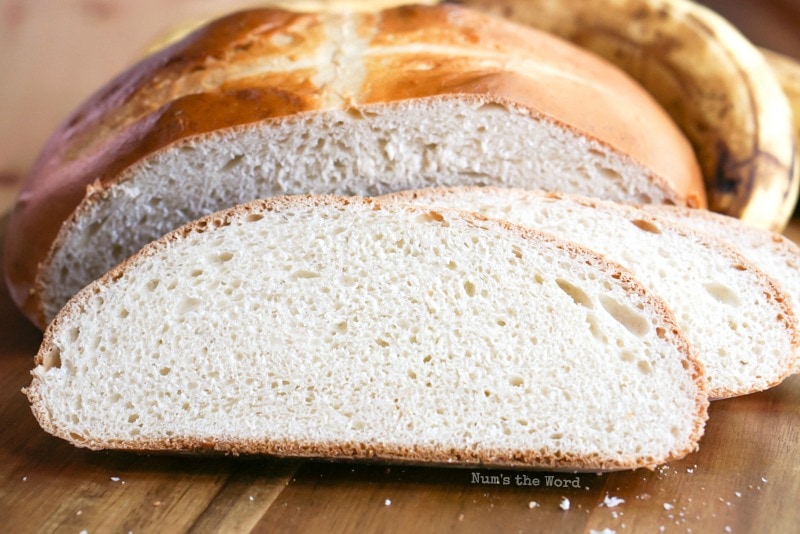 Banana Yeast Bread - Bread sliced with slices in front of loaf. Photo taken from front of bread.