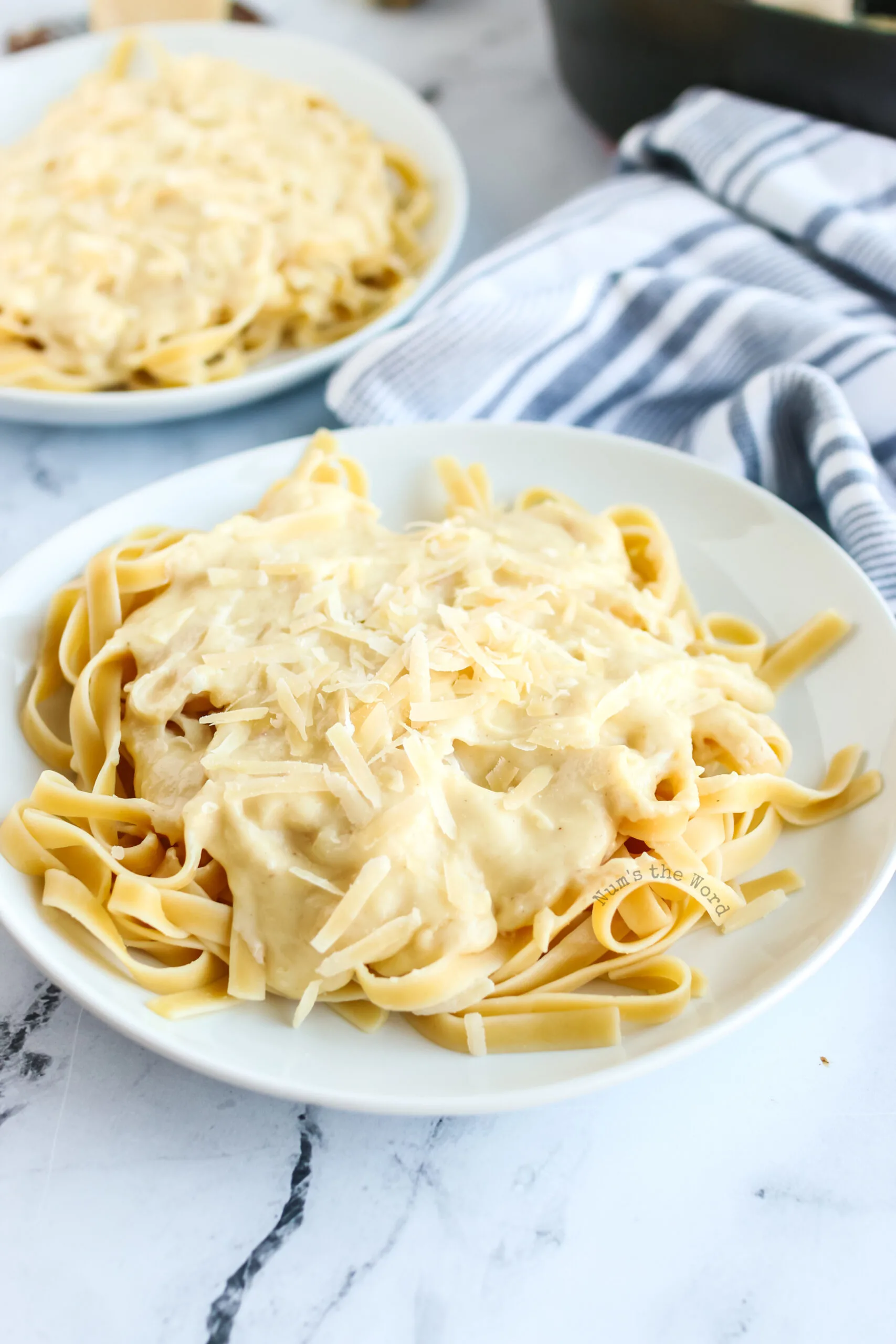 Alfredo poured over fettuccine noodles and topped with more parmesan