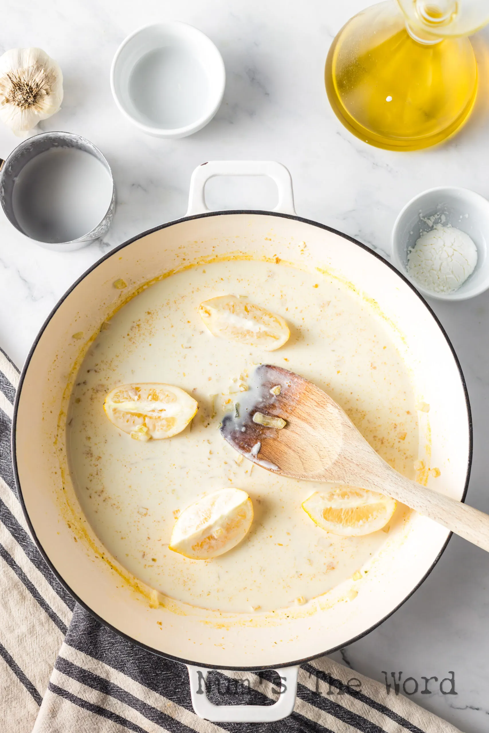 cream sauce cooking with lemon slices.