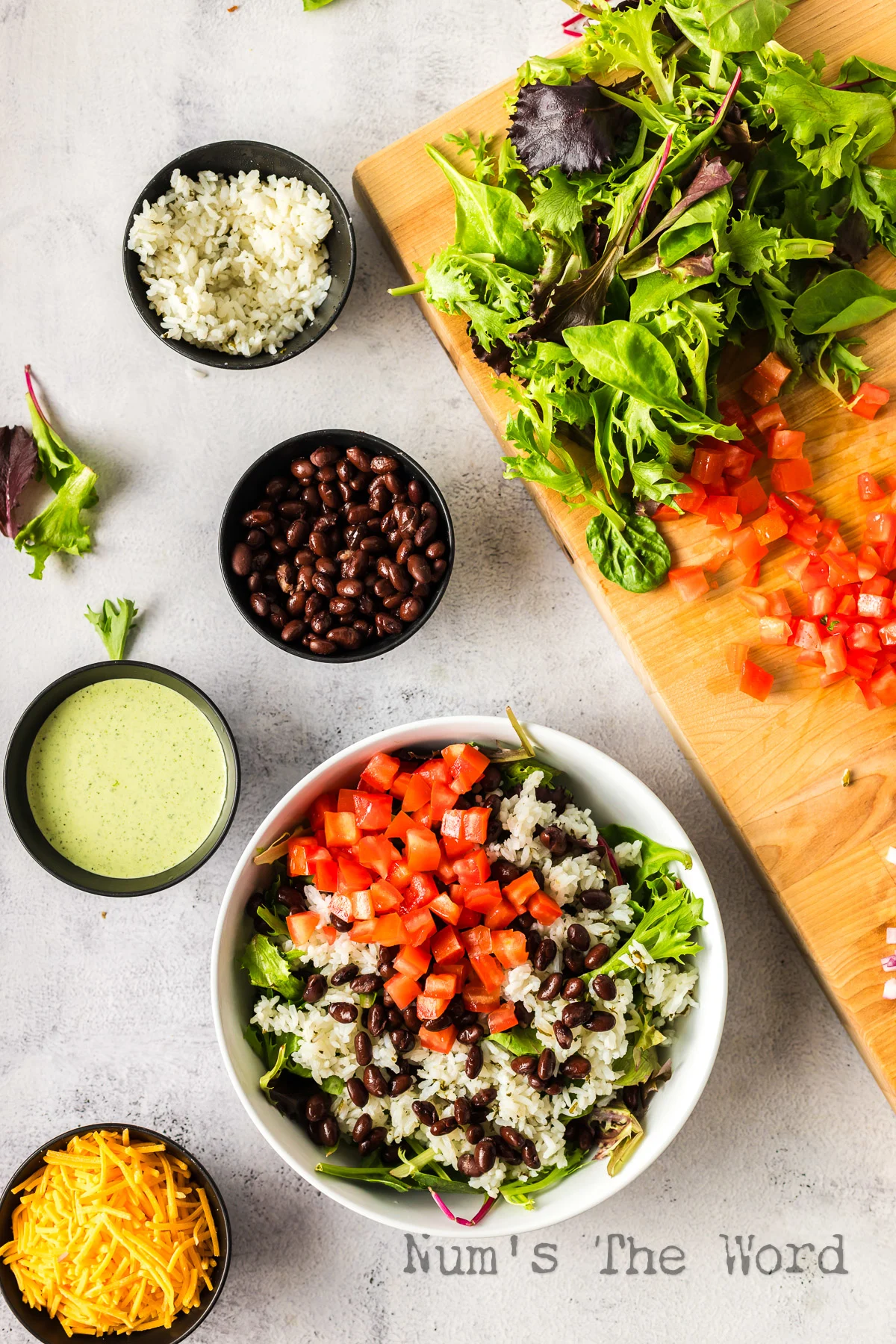 Tomatoes added to beans and rice in bowl.