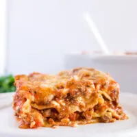 side view lasagna on plate with pan in background