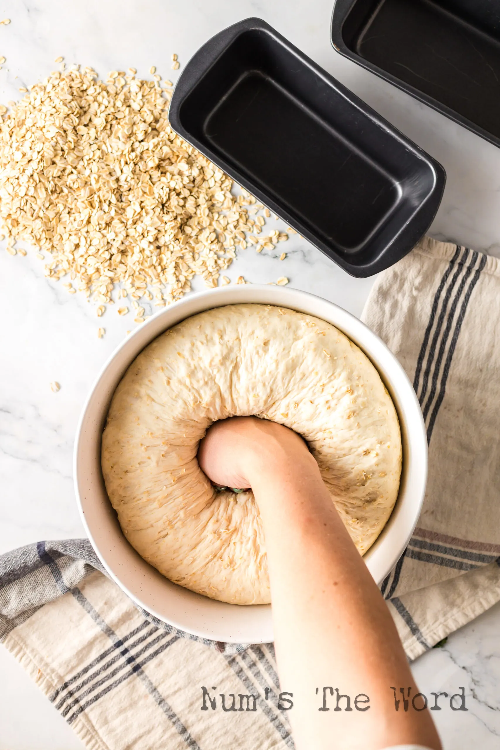 Hand punching bread dough down.