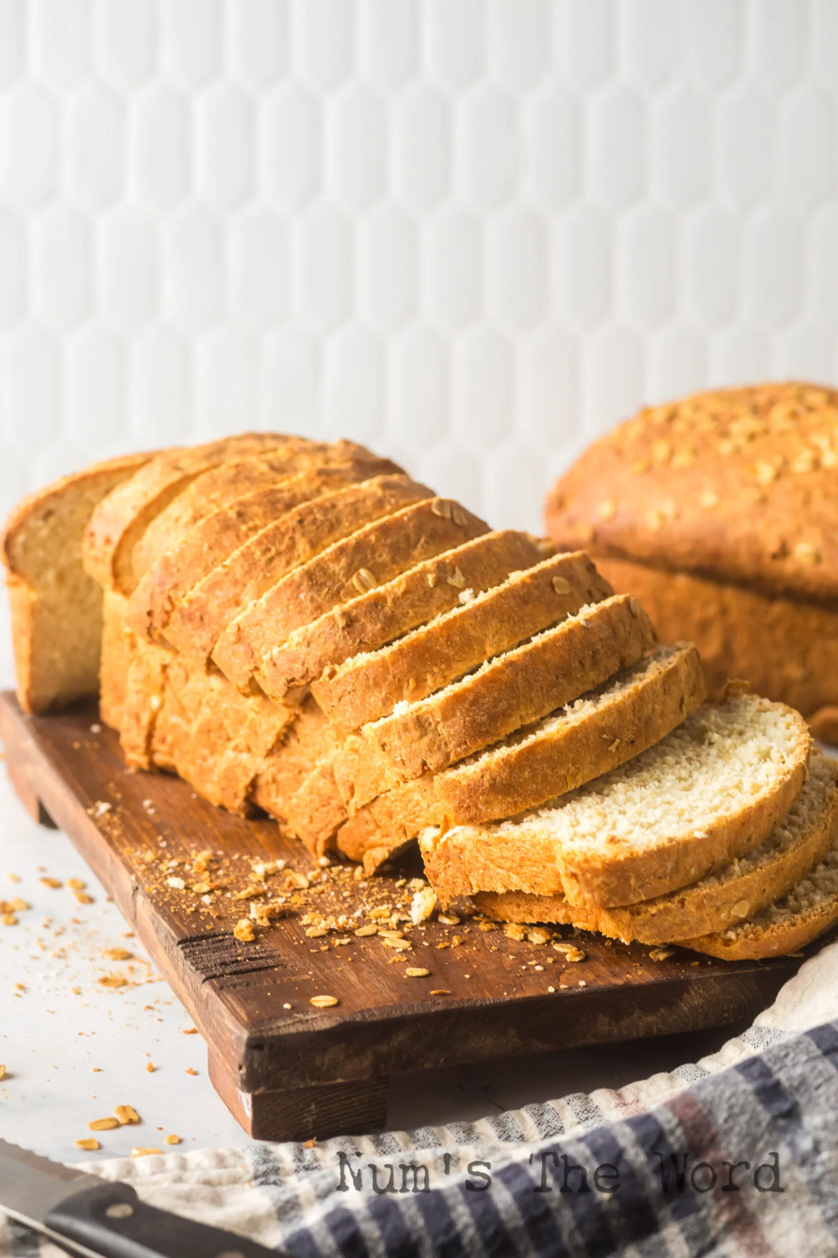 A loaf of bread sliced on cutting board.
