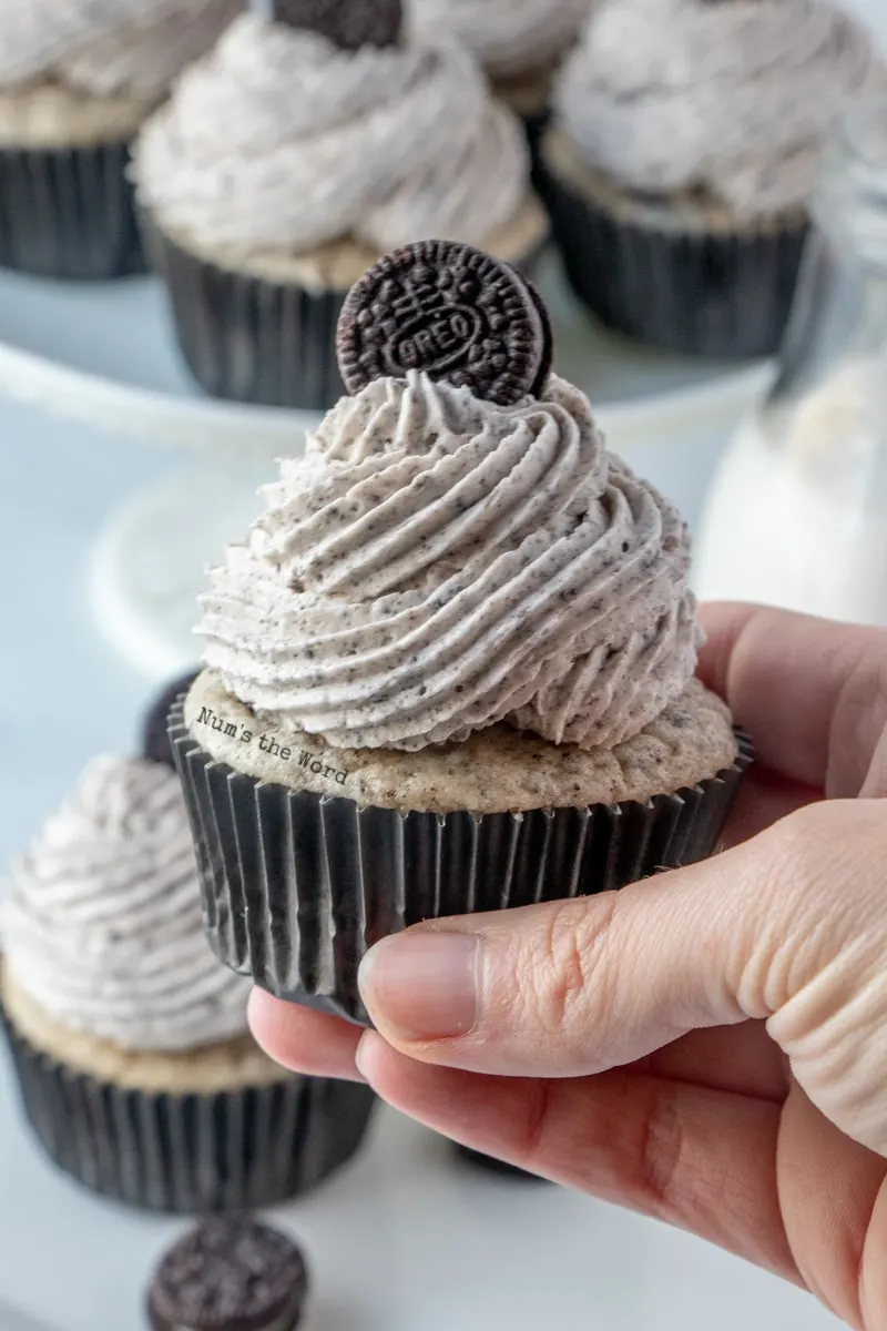 Oreo Icing - hand holding cupcake close to camera lens.