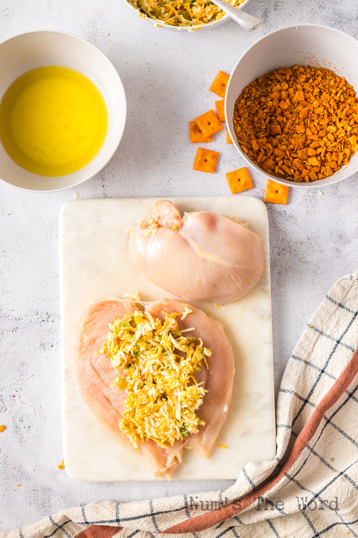 cheese mixture laid out on a flattened chicken breast